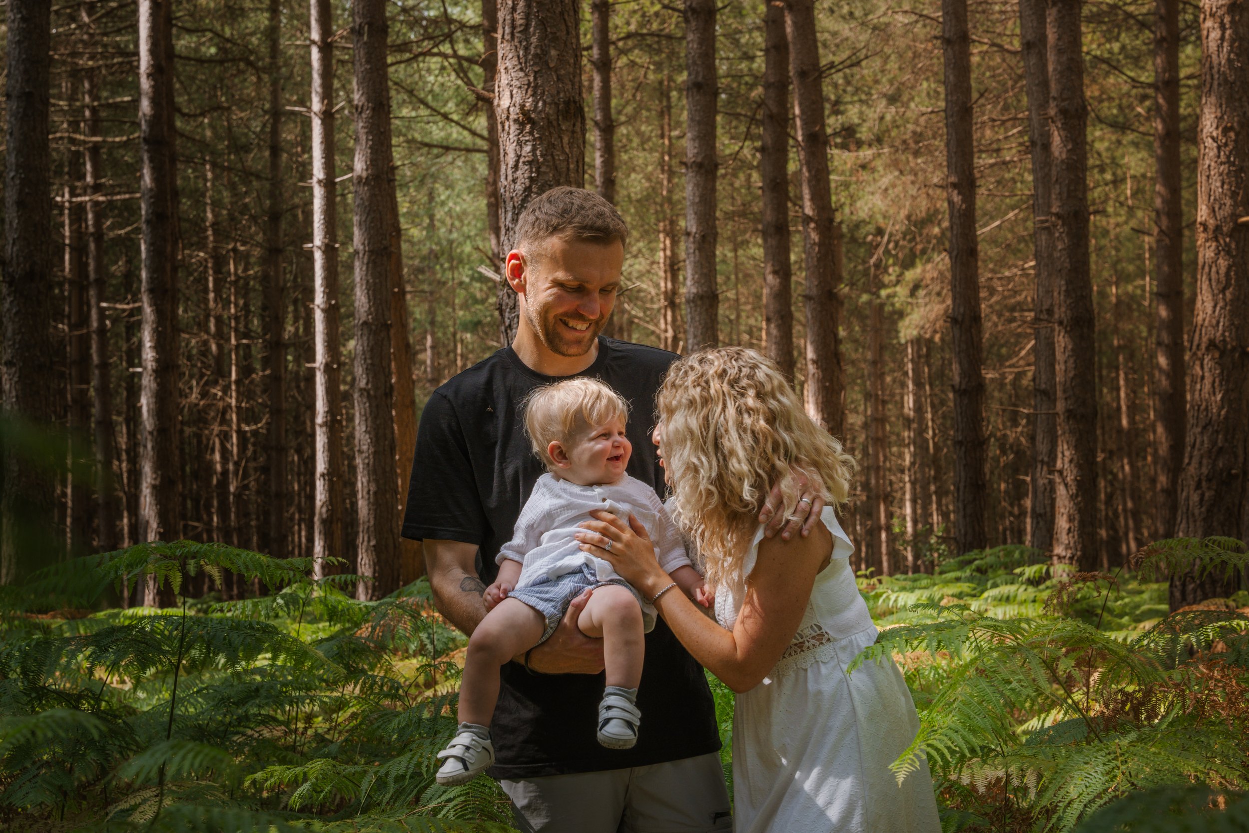 Family with a baby among woodland ferns