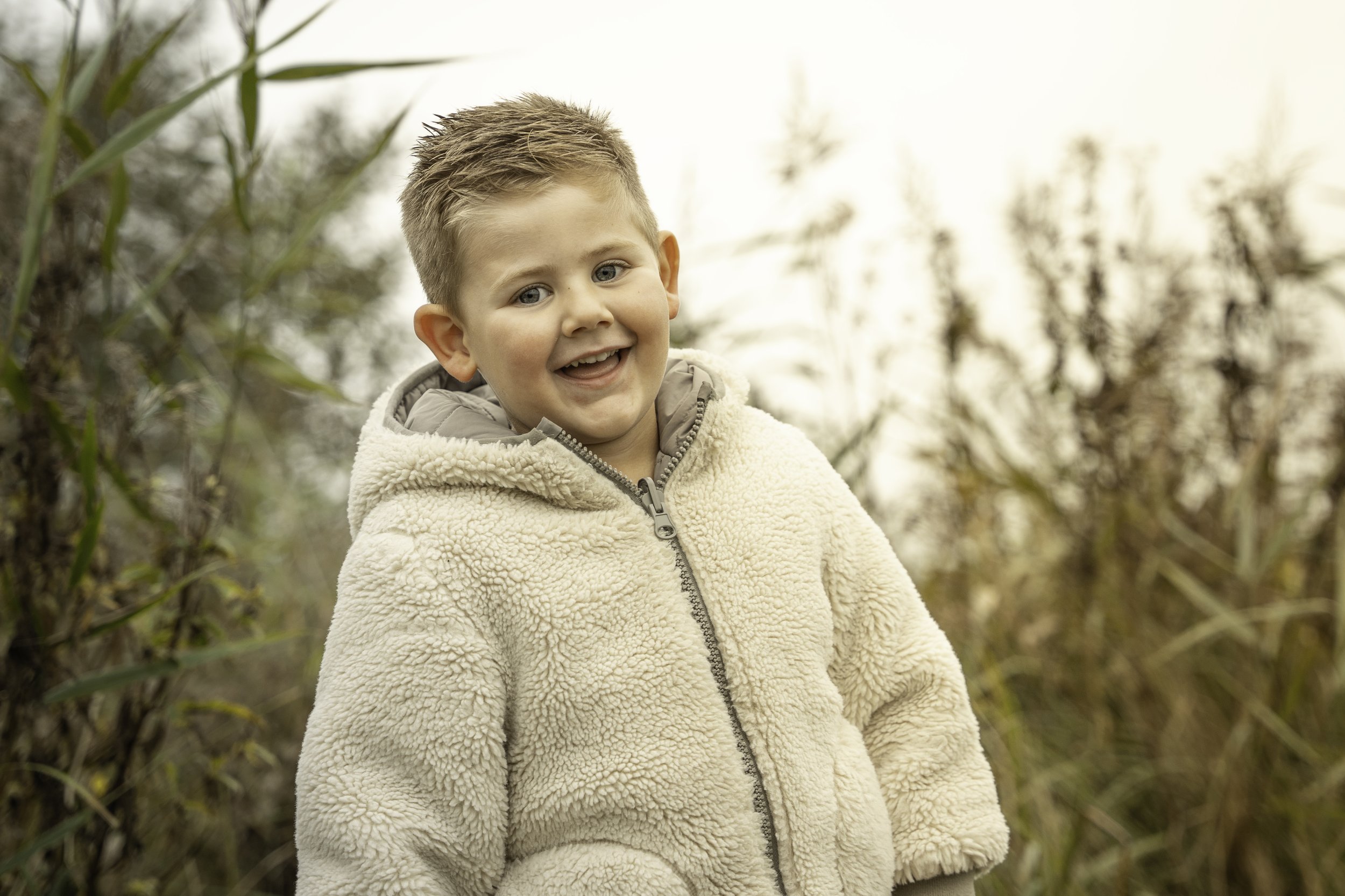 Smiling child in a cream fleece outdoors