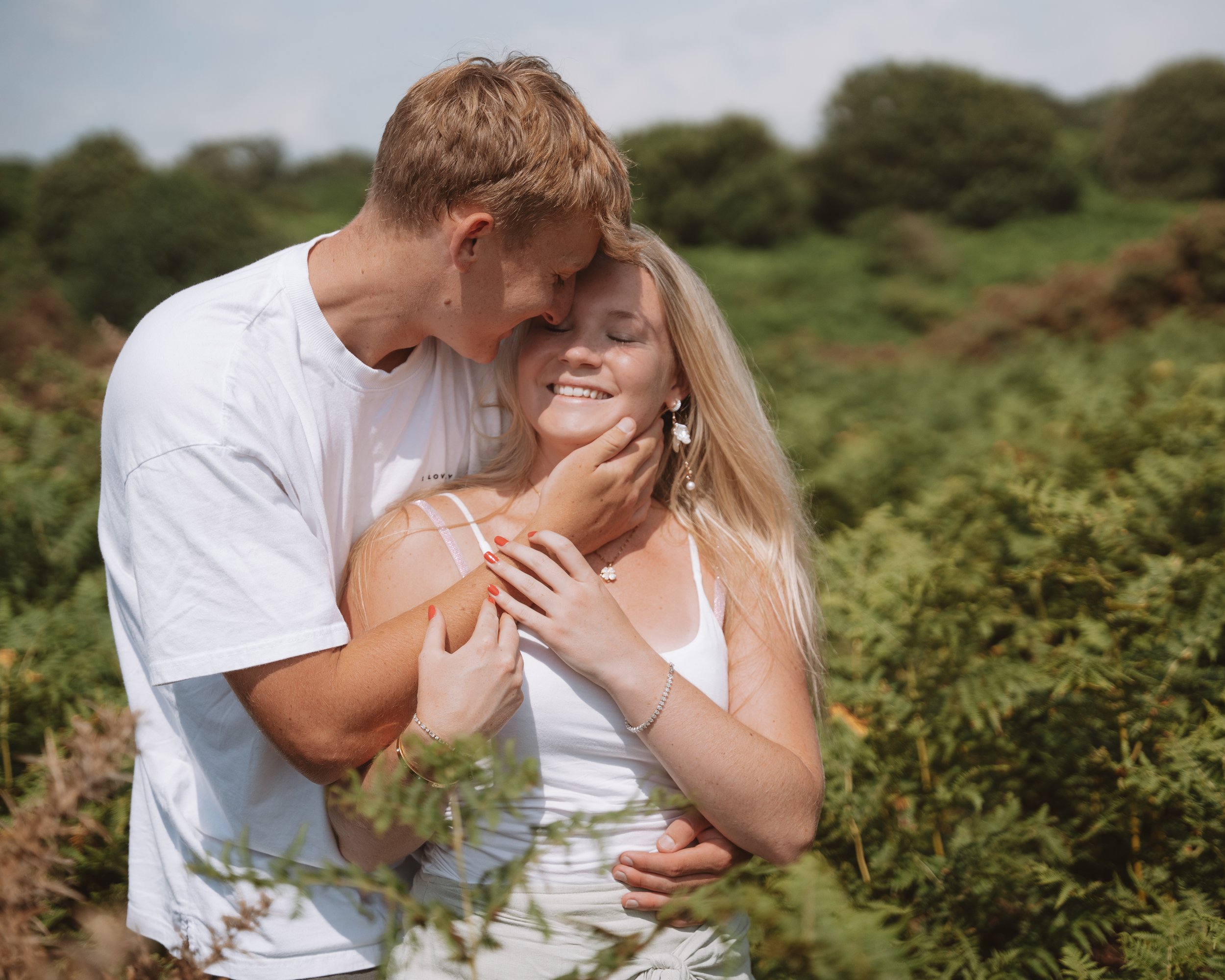 Couple embracing among green ferns