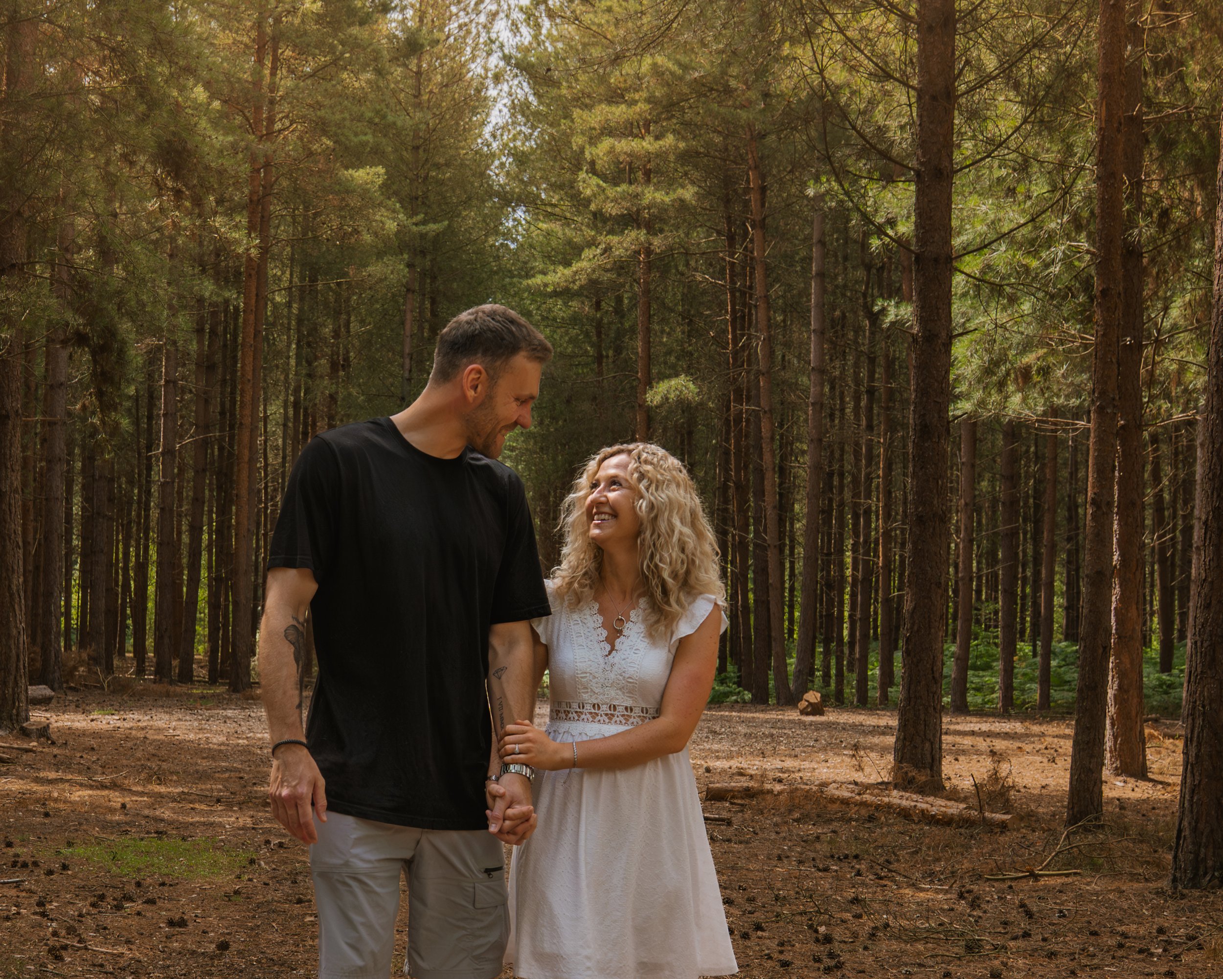 Couple holding hands in a pine woodland